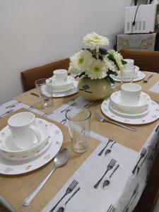 a table with plates and utensils on top of it at Lovely Condo 2-BR w/balcony in SM-Sucat, Paranaque in Manila