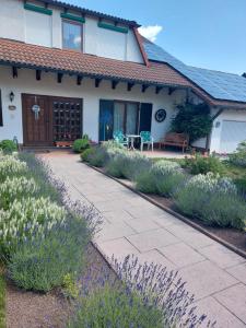 ein Haus mit einer Terrasse und Blumen davor in der Unterkunft Siggis Home in Wilhermsdorf