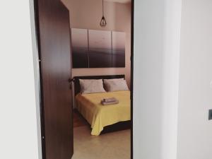 a bedroom with a bed with a yellow blanket at Studio apartment Gemelli in Poreč