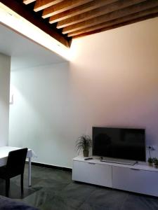 a living room with a flat screen tv on a white wall at Historic Suites 21 in Cartagena