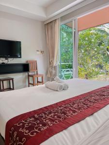 1 dormitorio con 1 cama y ventana grande en Naiyang Boutique Resort en Ban Phak Chit