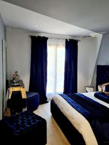 - une chambre avec 2 lits et une fenêtre avec des rideaux bleus dans l'établissement Magnifique villa de luxe au coeur de la garrigue, à Nîmes