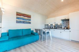 a living room with a blue couch and a table at Uzenabow in Wicie