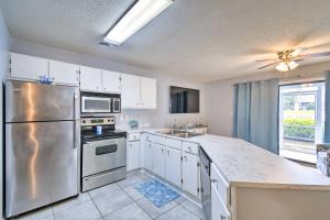 a kitchen with white cabinets and a stainless steel refrigerator at Little River Condo with Pool about 3 Mi to Beach! in Little River