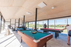 a group of people playing pool in a room with a pool table at Uzenabow in Wicie