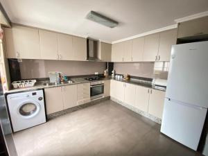 eine Küche mit weißen Schränken und einer Waschmaschine und einem Trockner in der Unterkunft Almudafer in Puerto de Sagunto + 15 Fotos