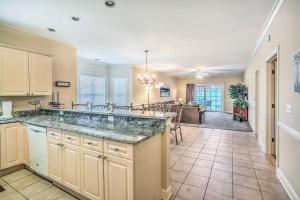 a kitchen with a large sink and a living room at Sunny Myrtlewood Condo with Golf and Pool Near Beach! in Myrtle Beach