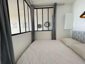 une petite chambre avec un lit et une fenêtre dans l'établissement Grand studio cabine 4 pers, balcon, rénové, proche océan, Saint-Hilaire-de-Riez - FR-1-224C-160, à Saint-Hilaire-de-Riez