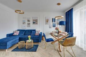 a living room with a blue couch and a table at TriApart Apartment Angielska Grobla DeLux in Gdańsk