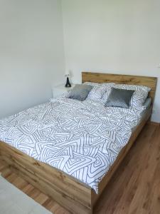 Ce lit se trouve dans un dortoir doté d'un mur blanc. dans l'établissement Uroczy Apartament Pod Skarpą, à Wadowice