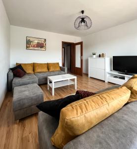 - un salon avec deux canapés et une télévision dans l'établissement Uroczy Apartament Pod Skarpą, à Wadowice