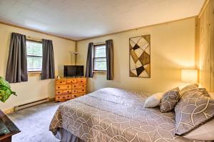 a bedroom with a bed and a tv and windows at Albrightsville Retreat with Community Pool and Hot Tub in Albrightsville