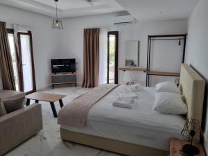 a bedroom with a large bed and a living room at MANGO Skiathos in Skiathos Town