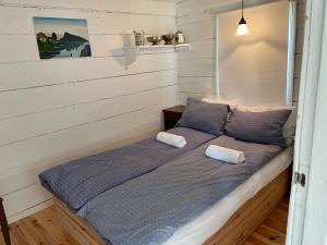 Una cama en una habitación con dos toallas. en Grandmothers cosy Farmhouse, en Fredvang