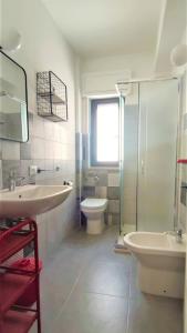 uma casa de banho com um WC, um lavatório e um chuveiro em fronte mare em Pozzallo