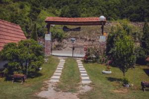 a garden with a gate and a path leading to a driveway at Rafting Kamp Dvije Vrbe in Foča
