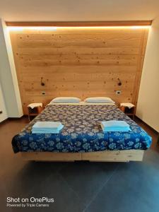 um quarto com uma cama e uma cabeceira em madeira em Chalet allemand em Sauze dʼOulx