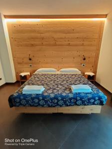 een slaapkamer met een bed met een houten hoofdeinde bij Chalet allemand in Sauze dʼOulx