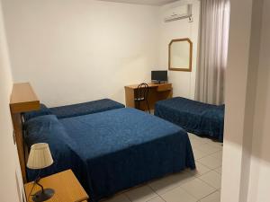 Pokój hotelowy z 2 łóżkami i biurkiem w obiekcie La Pergola w mieście Monte San Biagio