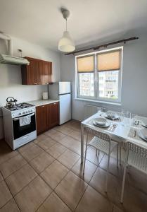 a kitchen with a table and a stove and refrigerator at Uroczy Apartament Pod Skarpą in Wadowice
