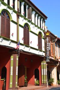 
a building with a clock on the front of it at Swiss Hotel Heritage Boutique Melaka in Malacca
