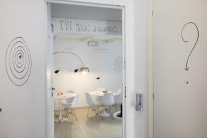 una stanza con tavoli e sedie bianchi e un cartello che legge la montagna magica di Boutique Hotel Novecento a La Spezia
