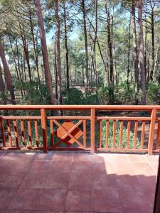 une clôture en bois avec un banc sur une terrasse dans l'établissement AGREABLE T2 LISIERE DU GOLF LACANAU OCEAN, à Lacanau-Océan