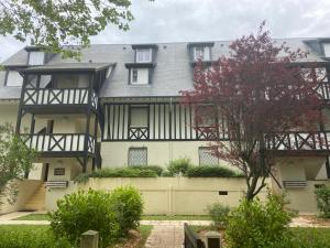 una casa grande con una valla delante en Studio en hypercentre refait à neuf avec une belle terrasse!, en Cabourg