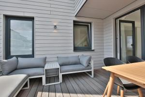 a porch with a couch and a table and chairs at Ostsee Suite 5 - Strandperle in Niendorf