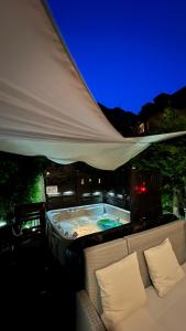 a hot tub under a tent with two chairs at San Marco Vip in Fluelen