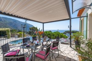 um pátio com mesas e cadeiras e vista para o oceano em Luxury Villa Panorama 5BD 5 BATH em Èze