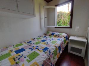 a small bedroom with a bed and a window at Bonito bungalow con jardín en playa Nerga in Hio