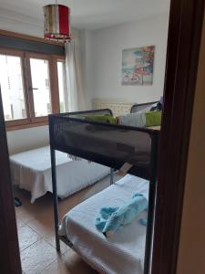 アヤモンテにあるApartamento Marina Esuriのベッドルーム1室(二段ベッド2台、窓付)が備わります。