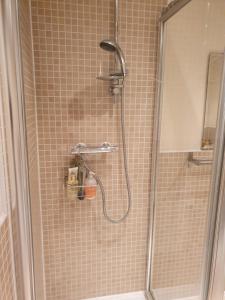 a shower with a shower head in a bathroom at Beautiful ensuite room in Wellingborough