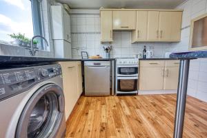 uma cozinha com máquina de lavar e secar roupa em Cosy 3 bed apartment in Southam, sleeps 6 em Southam