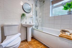a bathroom with a toilet and a sink and a mirror at Cosy 3 bed apartment in Southam, sleeps 6 in Southam