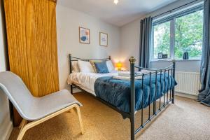 a bedroom with a bed and a chair and a window at Cosy 3 bed apartment in Southam, sleeps 6 in Southam