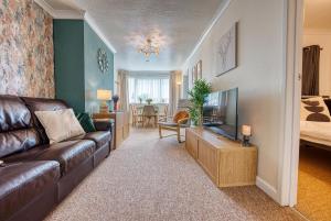 a living room with a couch and a television at Cosy 3 bed apartment in Southam, sleeps 6 in Southam +14 photos
