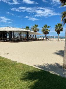 um edifício na praia com cadeiras e palmeiras em Durres, Apartment at Vala Mar rezidence, Hamallaj em Durrës