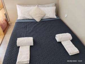 a bed with two rolled towels on it at Luxurious Japandi Loft in Ptolemaida