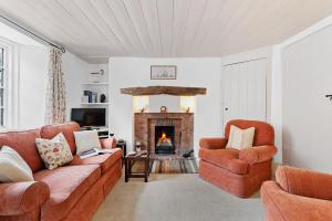 a living room with a couch and a fireplace at Curlew Cottage - Character Cottage with Superb River Views in Dittisham