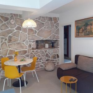 a living room with a table and a stone wall at Apartment Vanda in Splitska