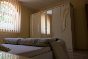 a bedroom with a bed and a cabinet and a window at Apartman Carsko in Rijeka
