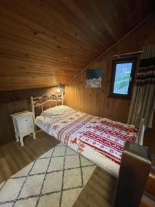 a bedroom with a bed in a wooden cabin at Le Chalet de Goncelin in Goncelin
