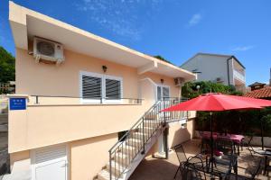 a balcony with tables and a red umbrella at Apartments Dida in Hvar