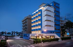 a tall white building with a street light in front of it at Hotel Apollo in Riccione