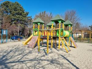 um parque infantil com escorrega num parque em Lilian apartmanház em Siófok