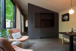 una sala de estar con una silla rosa y una mesa. en Adelaerthoeve Logies & Ontbijt en Arnhem