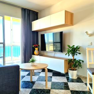 een woonkamer met een tafel en een televisie bij Torremolinos holiday Sun & Sea in Torremolinos