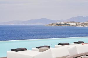 a row of chairs sitting on top of a beach at Kouros Hotel & Suites in Mikonos